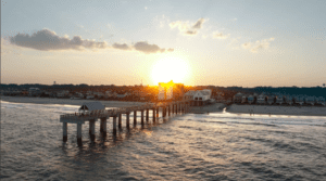 Hotel drone video content capturing sunset over Surfside Beach pier and Surfside Oceanfront Hotel in South Carolina